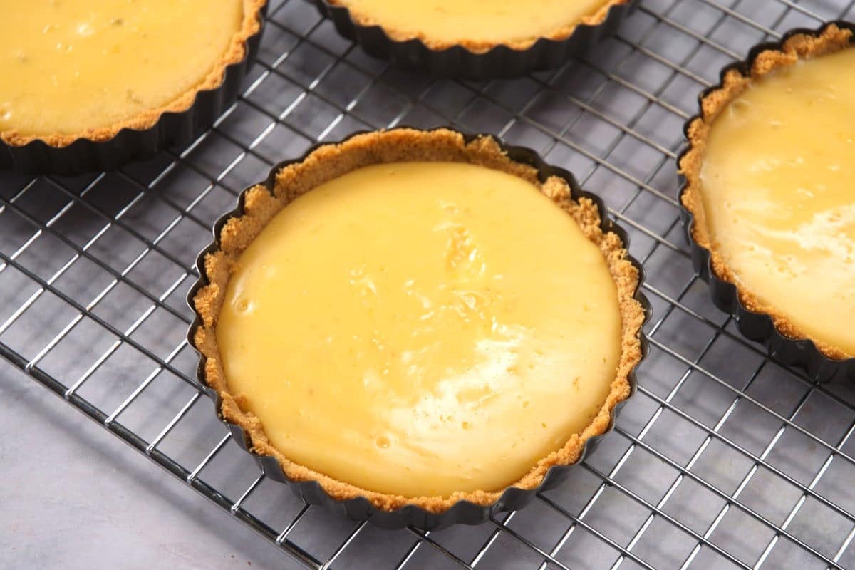 Baked mini key lime pies on baking rack.