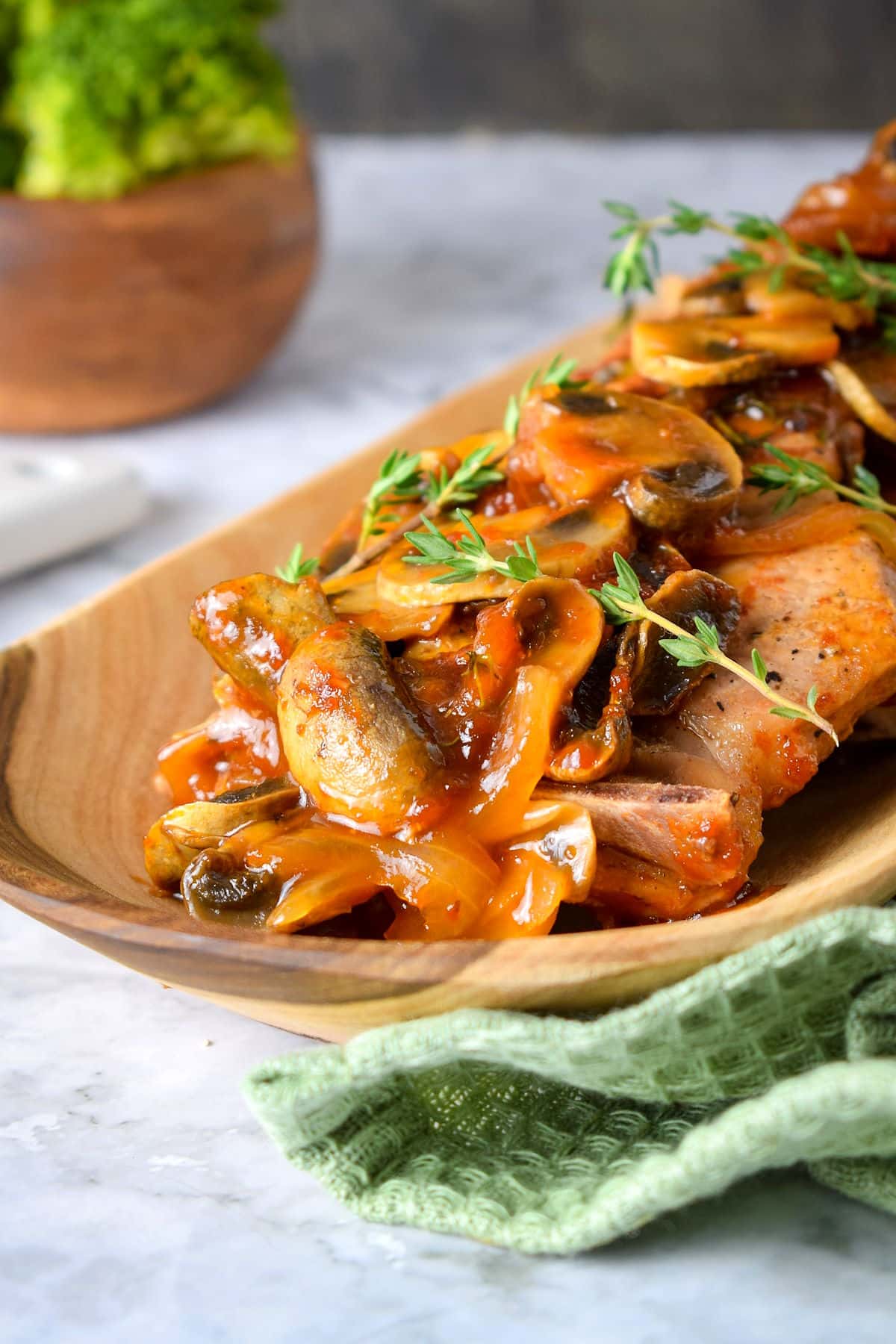 Pork chops with gravy and mushrooms in serving dish.