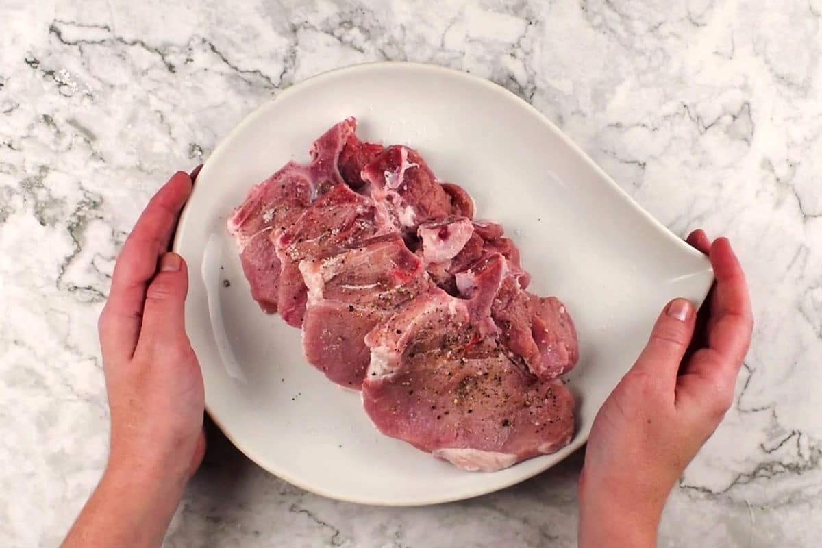 Seasoned raw pork chops.