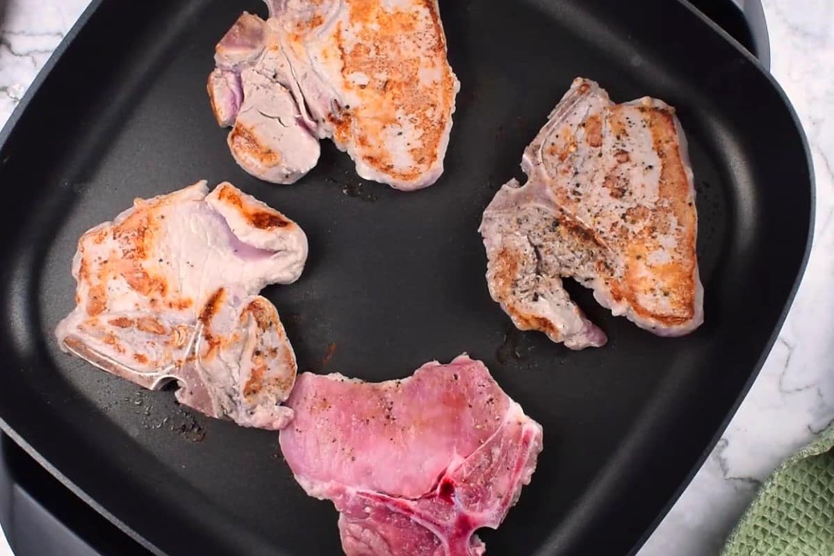 Browned pork chops in electric skillet.