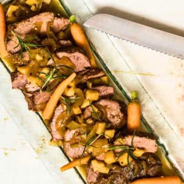 Electric skillet pot roast with vegetables on serving tray.