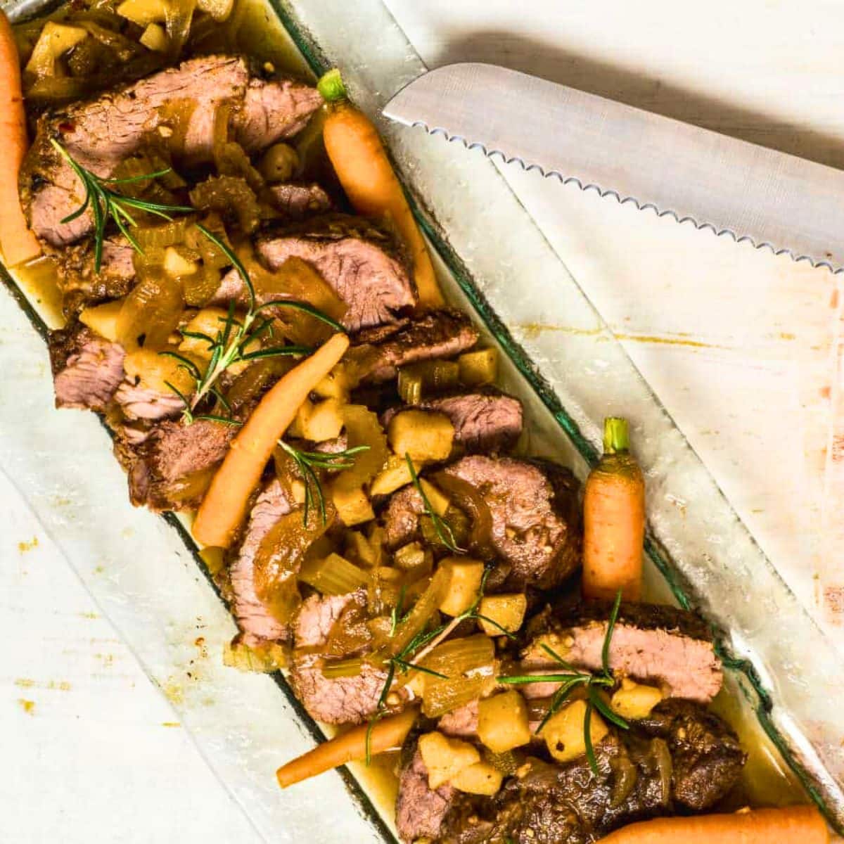 Electric skillet pot roast with vegetables on serving tray.