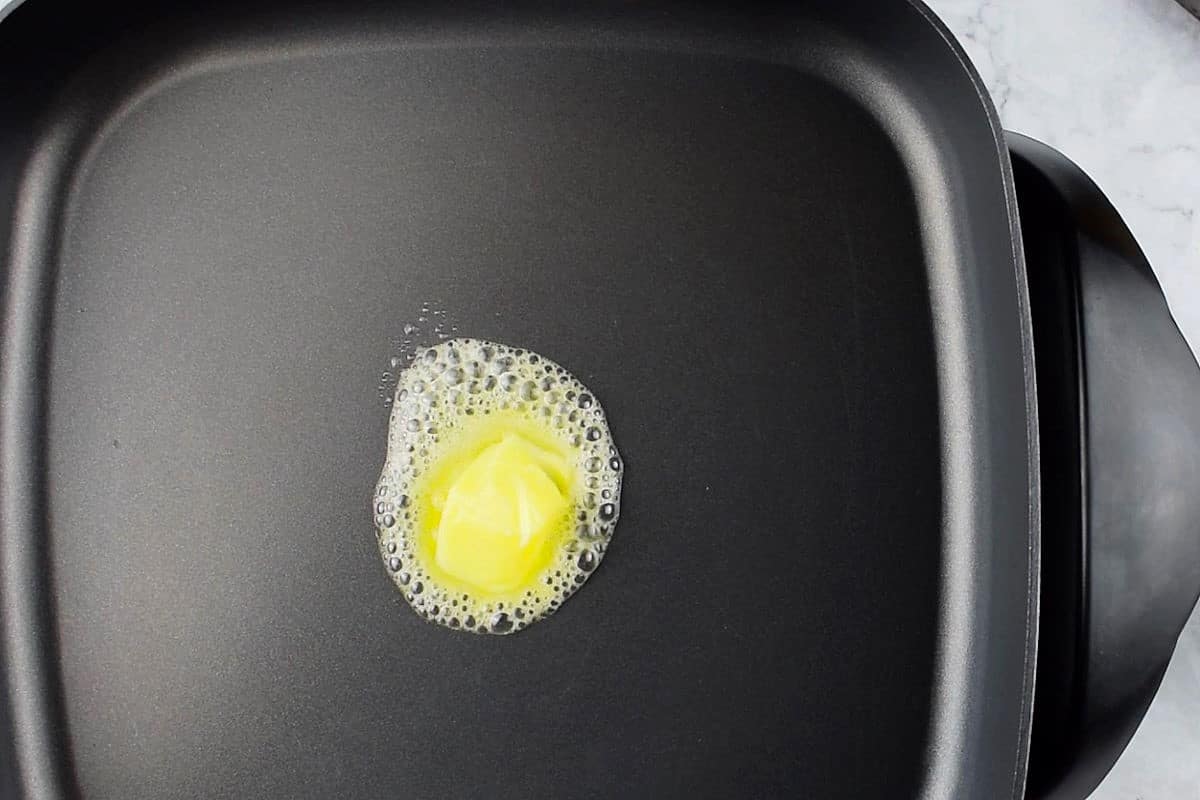 Butter melting in an electric skillet.