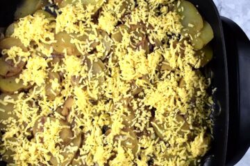 Scalloped potatoes with cheese in an electric skillet.