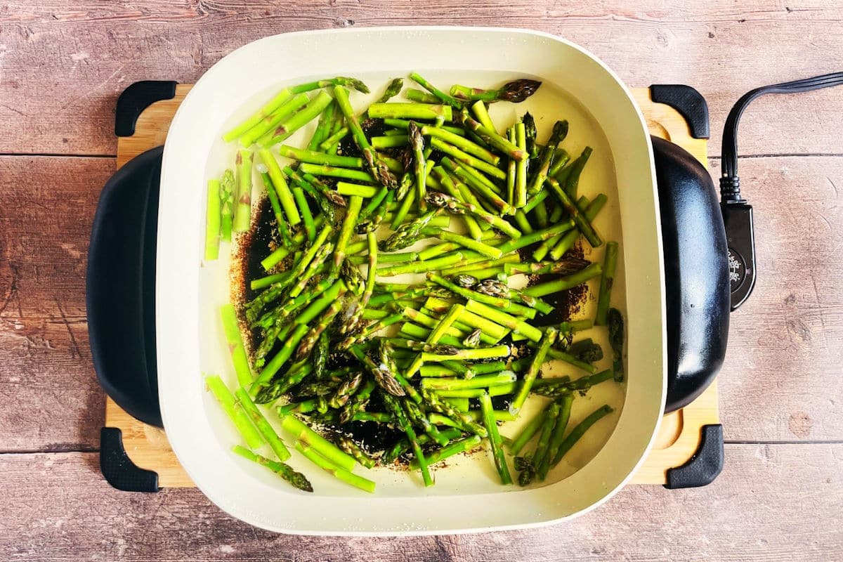 Asparagus cooking in electric skillet.