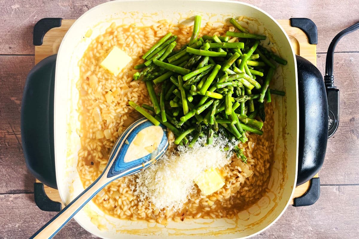 Risotto with asparagus, white wine, Parmesan and butter in electric skillet.