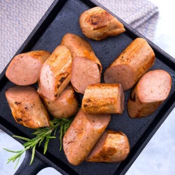 Sausage sliced on a small cast iron tray.