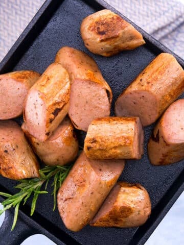 Sausage sliced on a small cast iron tray.