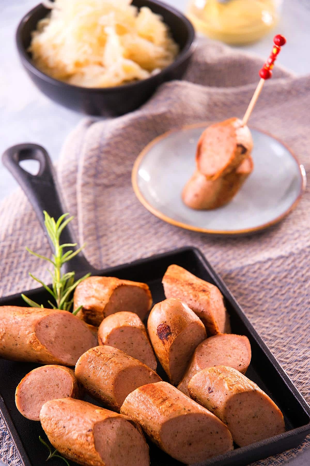 Electric skillet sausage on a cast iron dish.