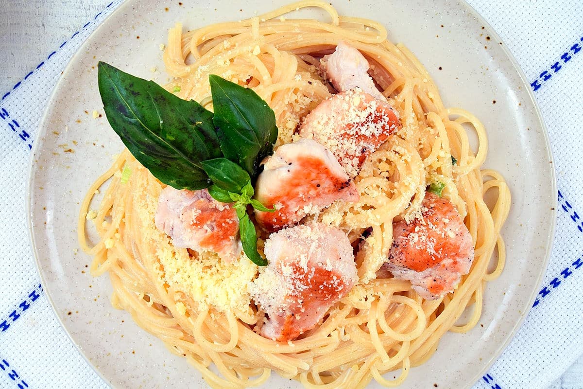 Electric skillet spaghetti on plate with fresh basil.