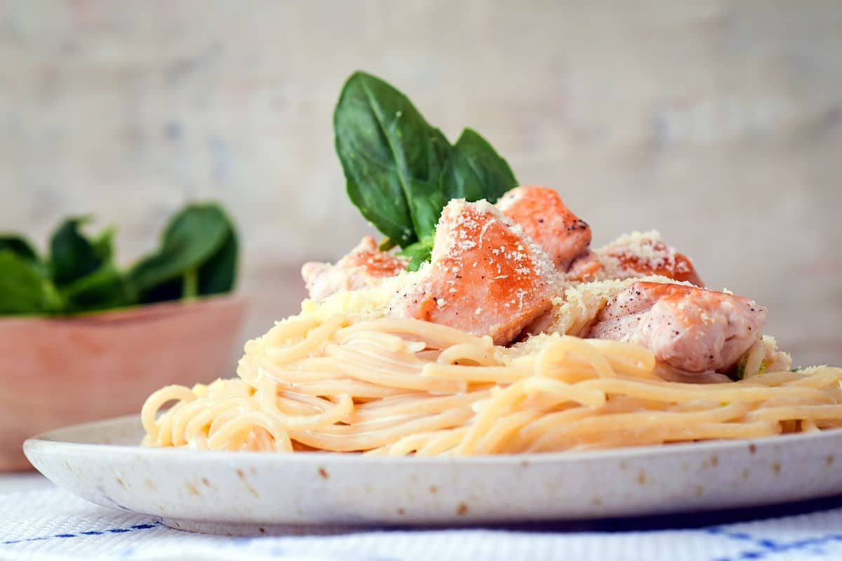 Electric skillet spaghetti with cubed chicken on plate.