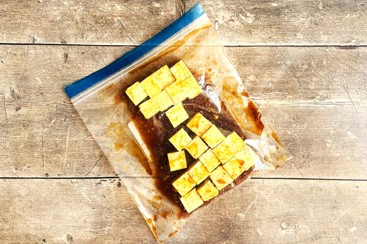 Tofu cubes marinating in zip-top bag.