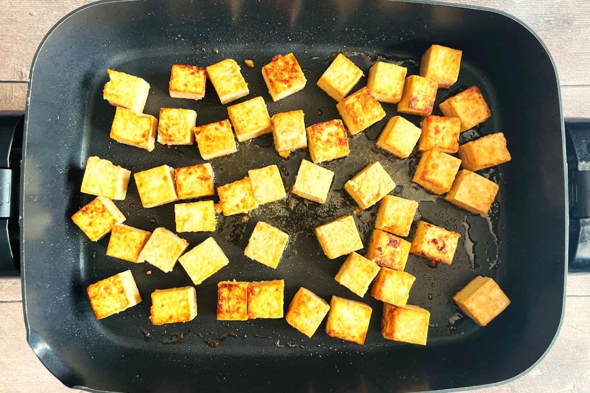 Tofu cubes fried in electric skillet.