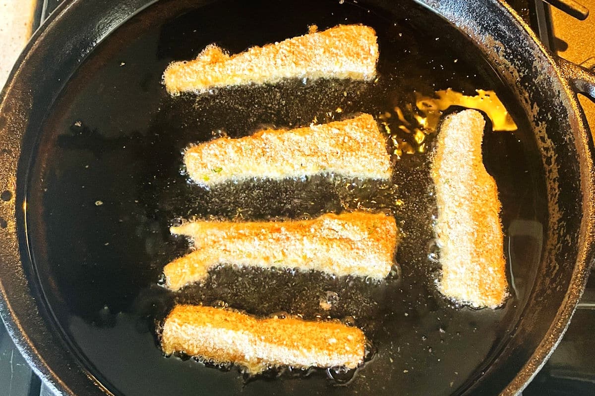 Fish sticks frying in pan.