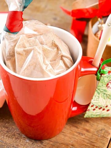 Chocolate mug cake mix in a red mug with Christmas gift label.