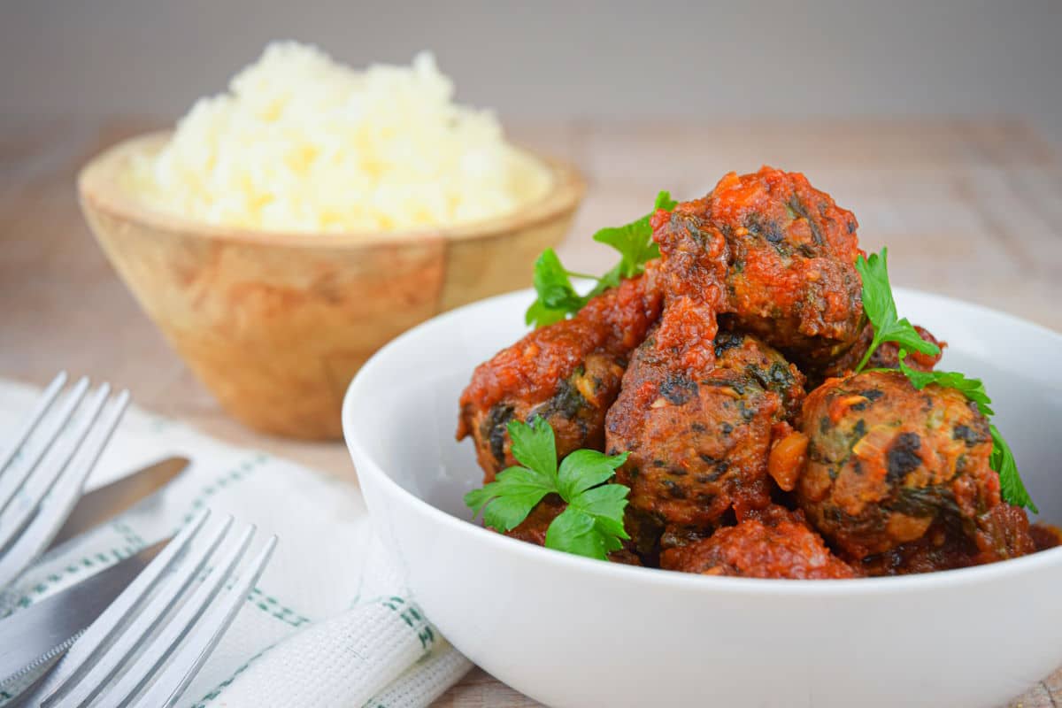 Turkey meatballs in tomato sauce in white bowl.