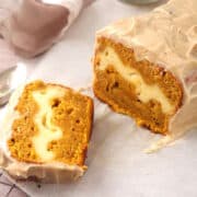 Frosted pumpkin cream cheese bread sliced open.