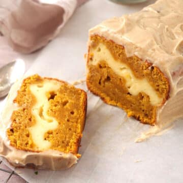 Frosted pumpkin cream cheese bread sliced open.