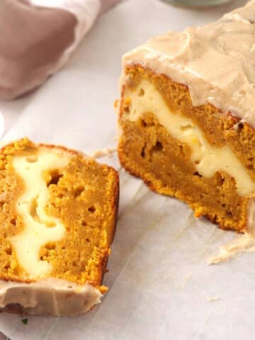 Frosted pumpkin cream cheese bread sliced open.