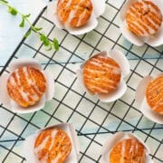 Carrot cupcakes on baking rack with vegan frosting.