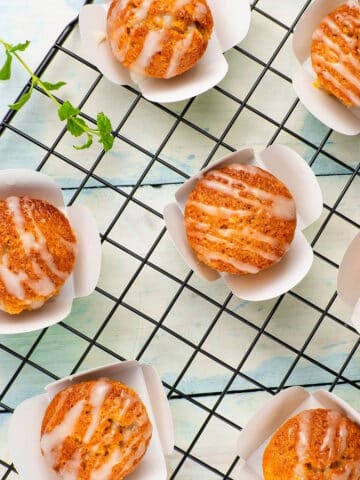 Carrot cupcakes on baking rack with vegan frosting.