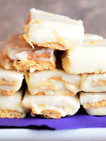 Graham wafer lemon bars stacked on purple napkin.