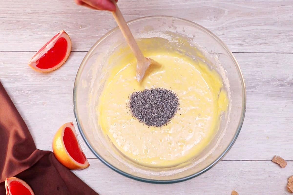 Grapefruit cake batter in bowl with poppy seeds.