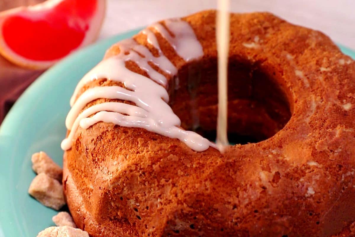 Grapefruit cake getting drizzled with icing.