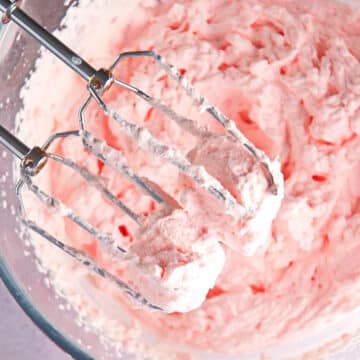 Grenadine whipped cream in bowl with electric mixer.