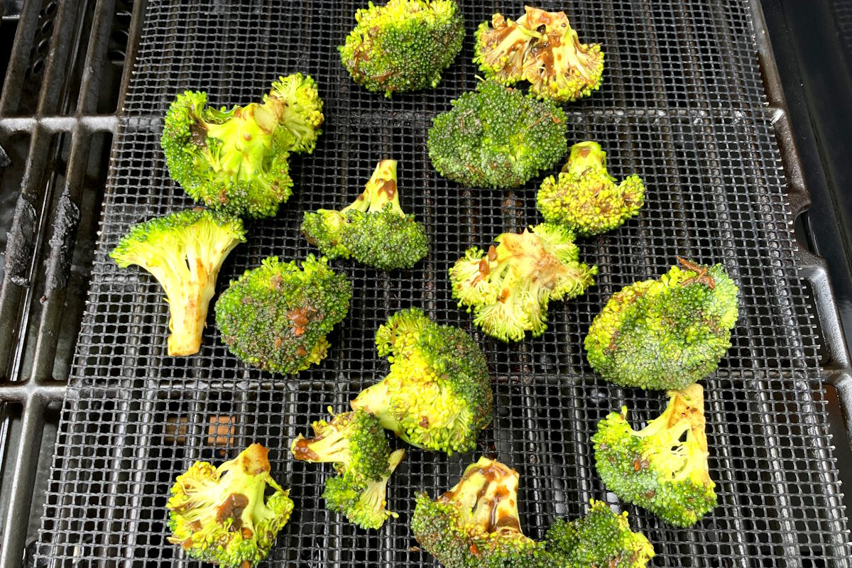Grilled broccoli on grill mat.