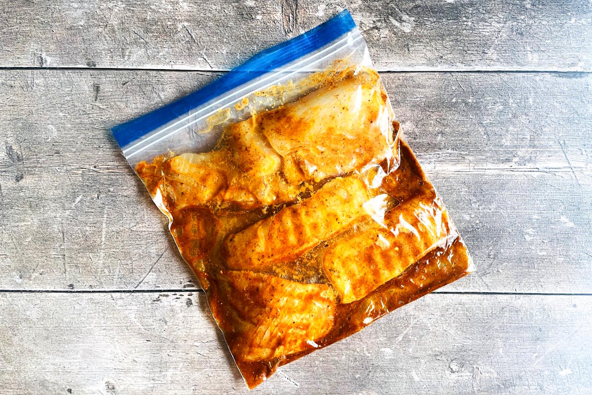 Halibut in marinade in zip-top bag.