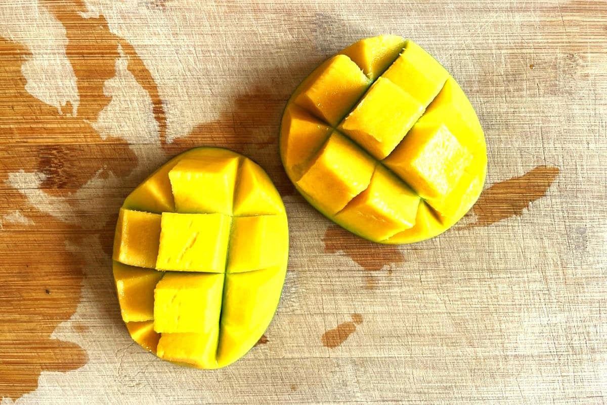 Mango cubes on cutting board.