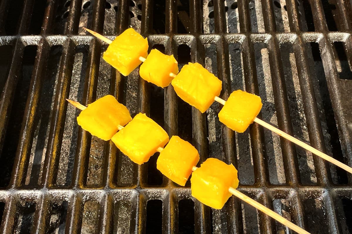 Mango skewers on grill.