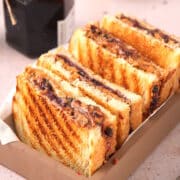 Grilled PBJ sandwiches cut in half in serving dish.