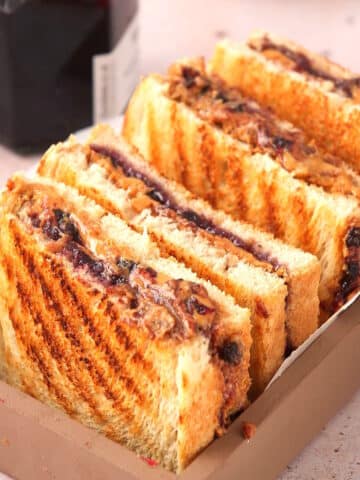 Grilled PBJ sandwiches cut in half in serving dish.
