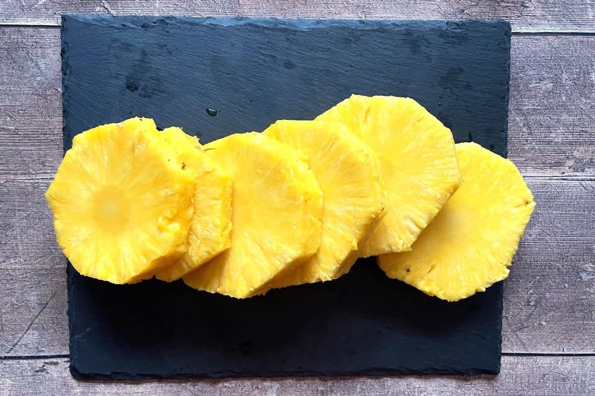 Pineapple slices on black board.