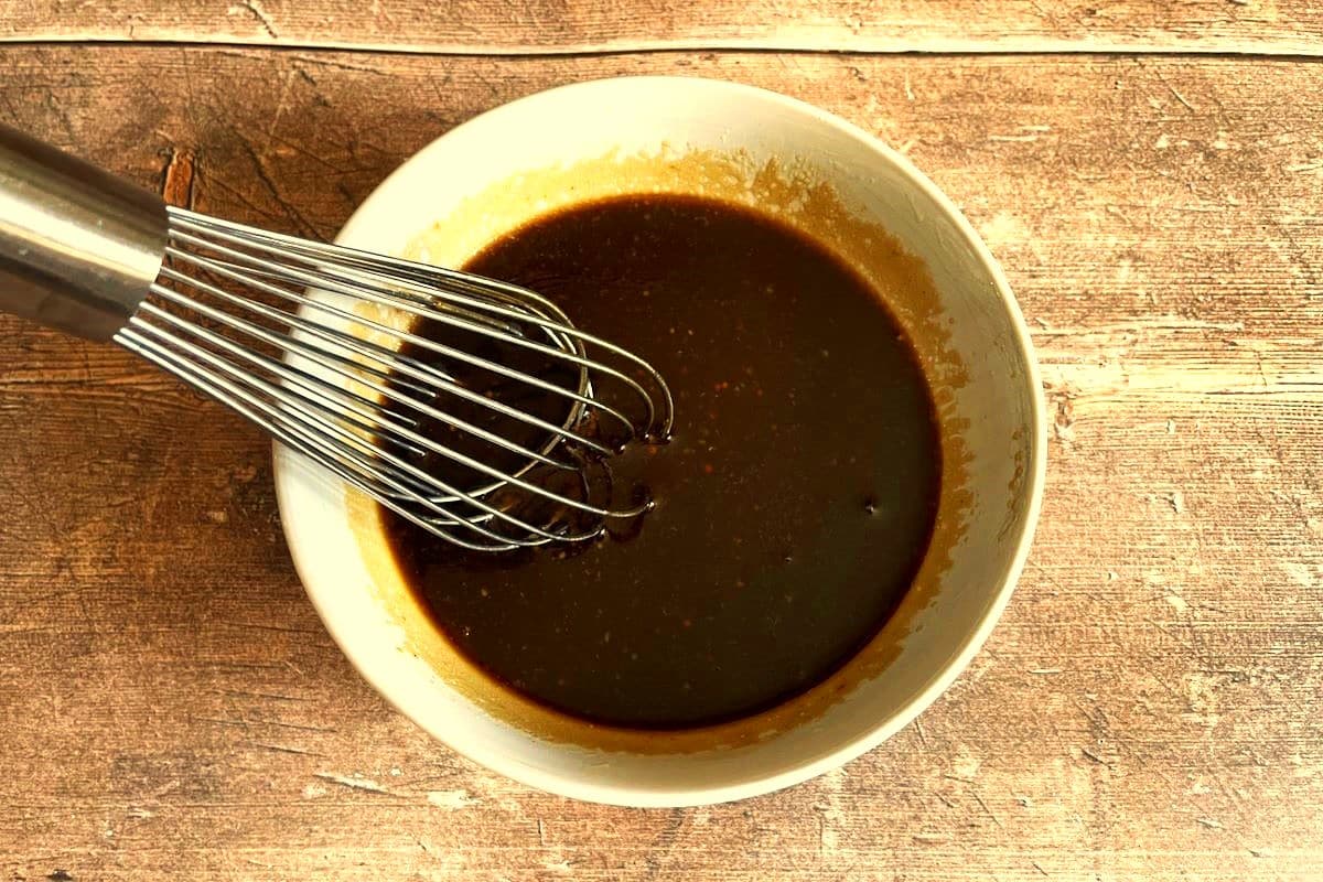 Finished balsamic drizzle in bowl with whisk.