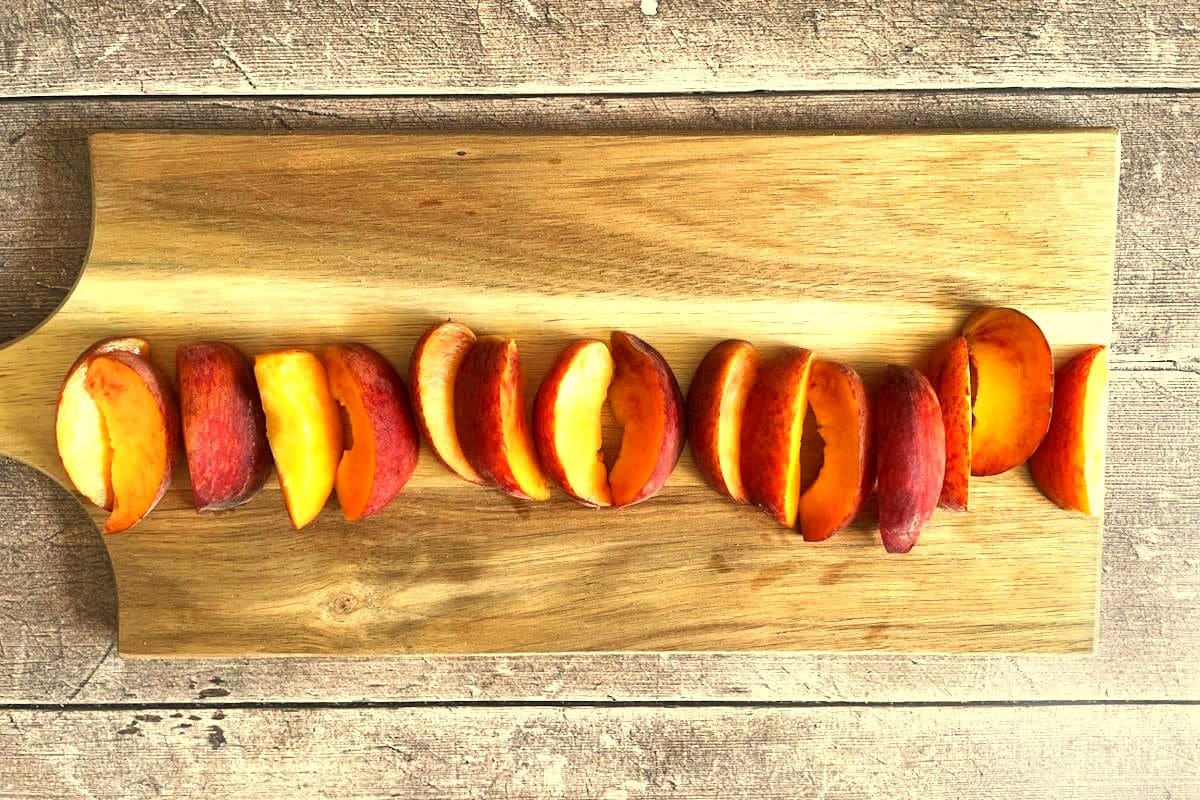 Peach wedges on cutting board.