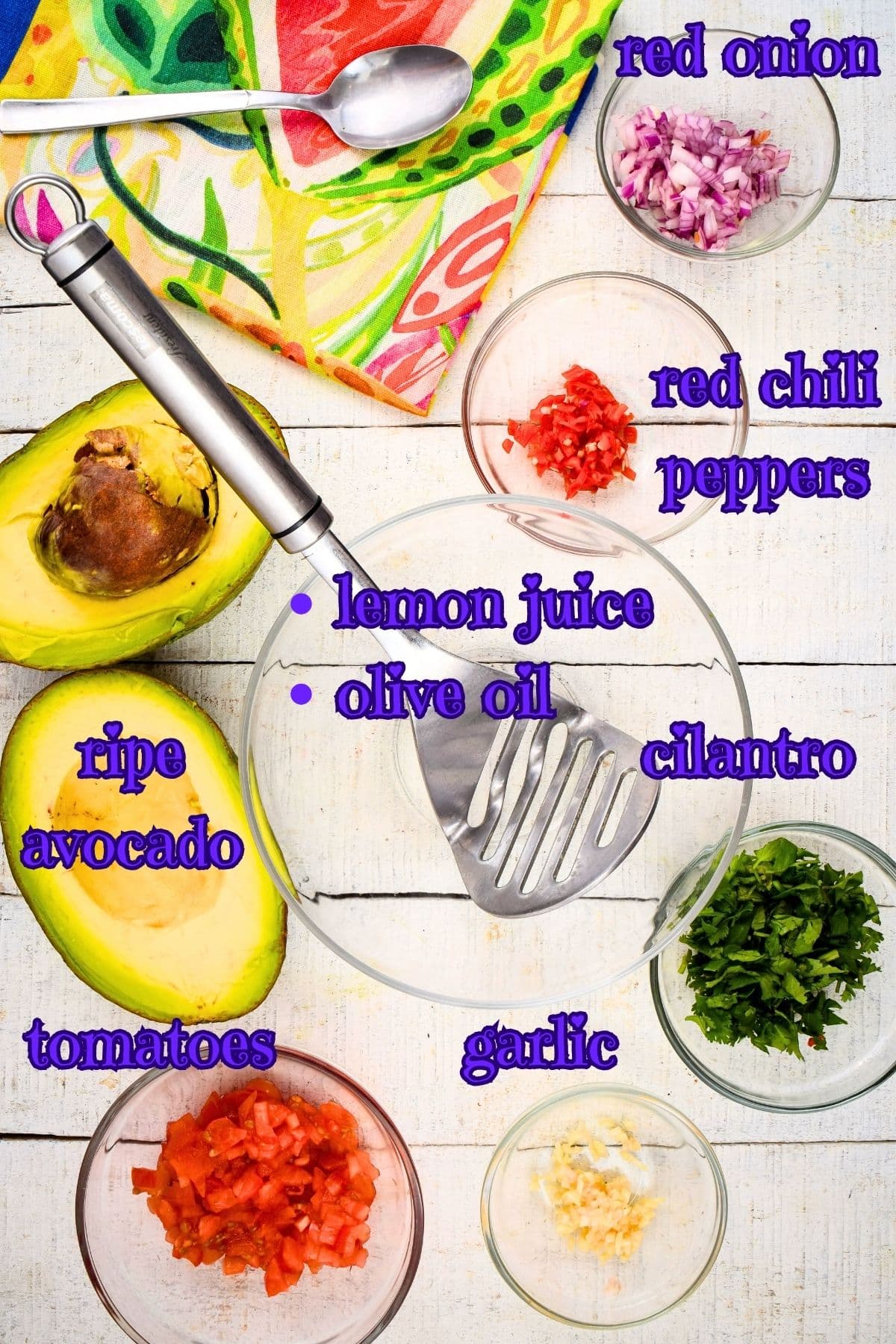 Guacamole ingredients prepped on white wooden background.
