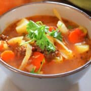 Beef and cabbage soup in blue soup bowl.