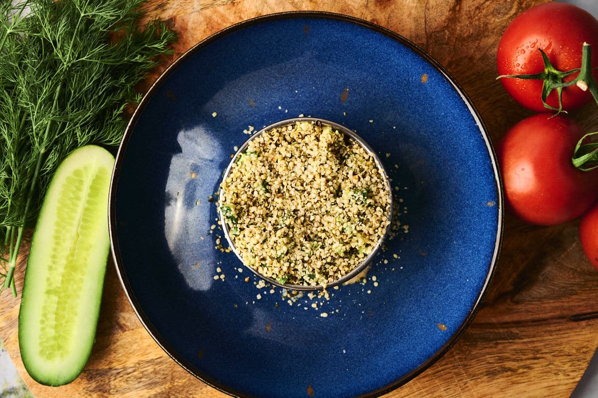 Hemp seed salad on blue plate in round mold.