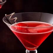 Hibiscus cosmo in martini glass with cherry.