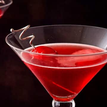 Hibiscus cosmo in martini glass with cherry.