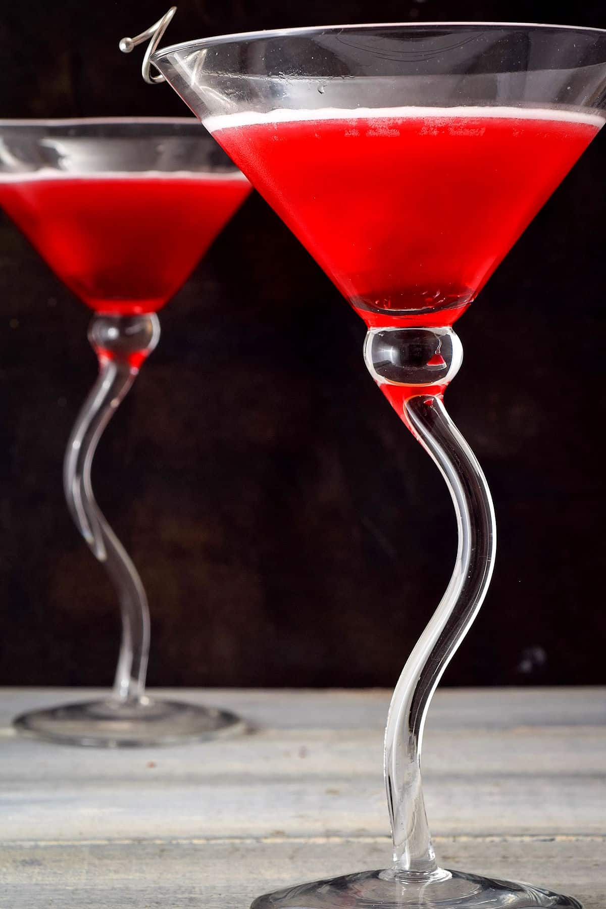 Hibiscus cosmo in martini glasses on black background.
