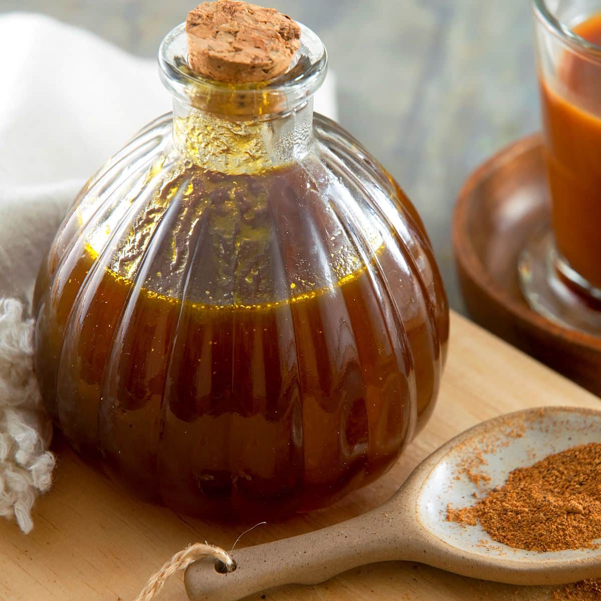 Pumpkin spice syrup in bottle with pumpkin pie spices in a spoon.
