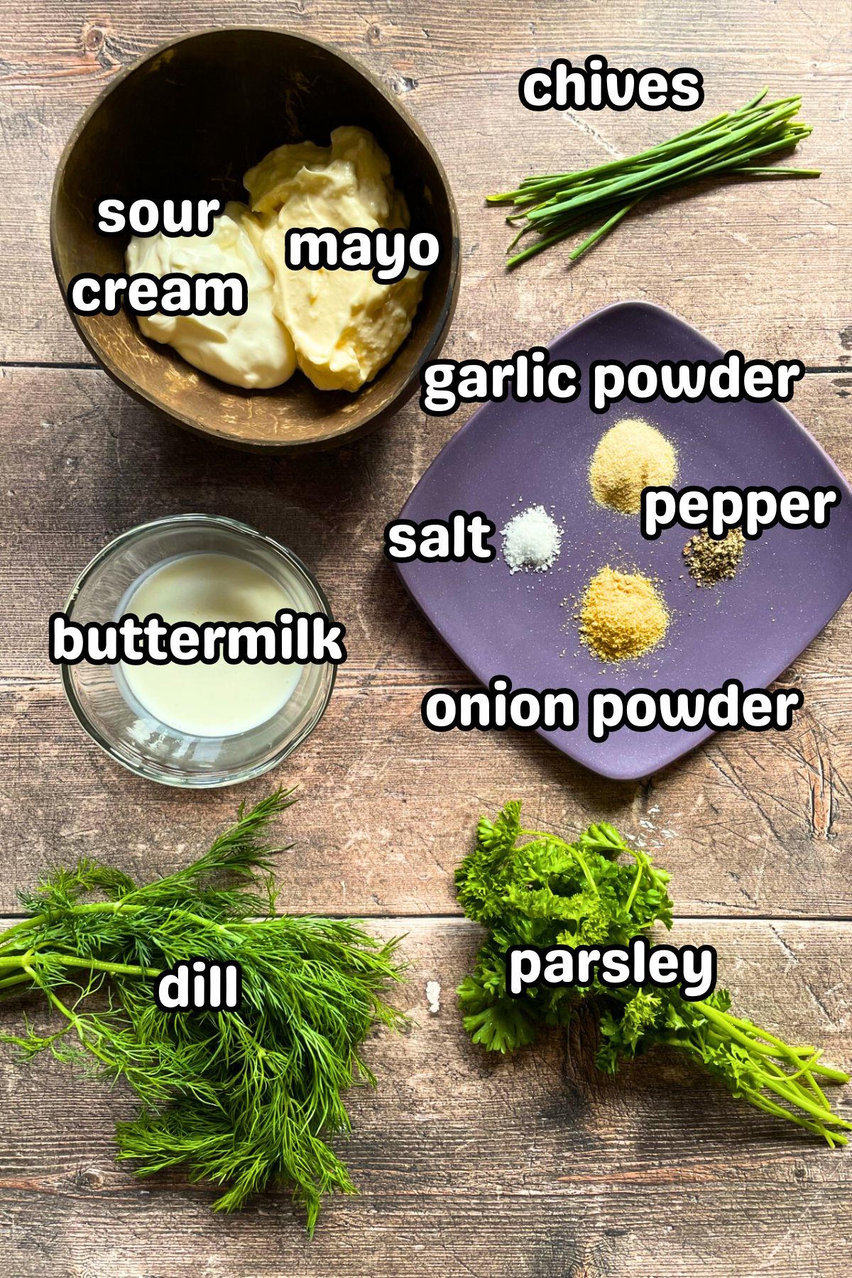 Homemade ranch dressing ingredients prepped and labeled on brown wooden background.