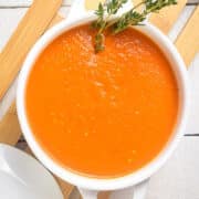 Homemade roasted garlic tomato soup in white soup bowl.