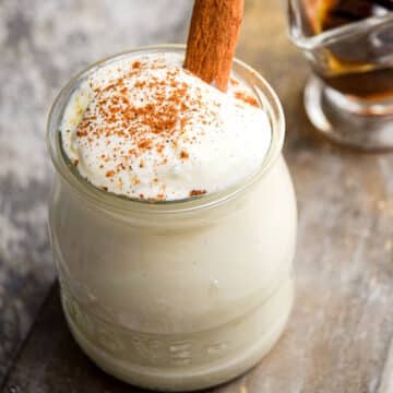 Whipped cream topping in jar with cinnamon stick.