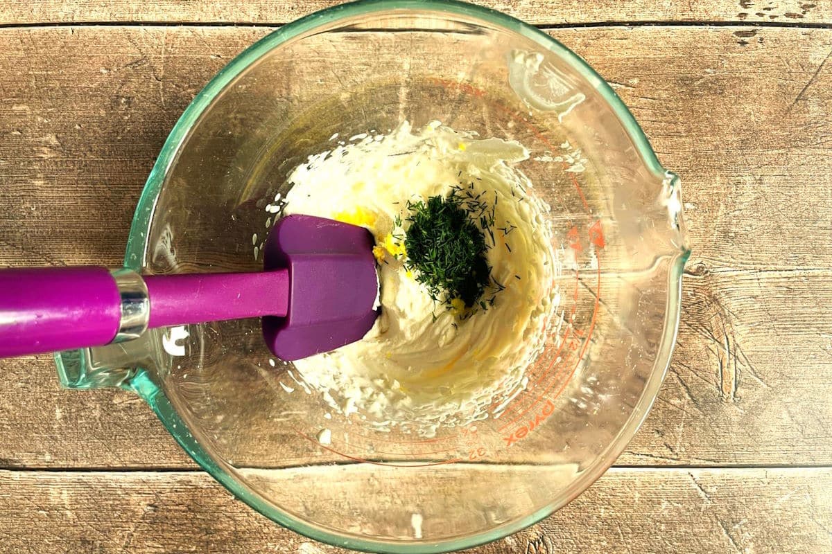 Lemon and dill getting folded into whipped cream.