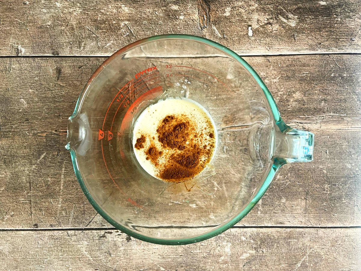 Pumpkin pie spice whipped topping ingredients in measuring glass.